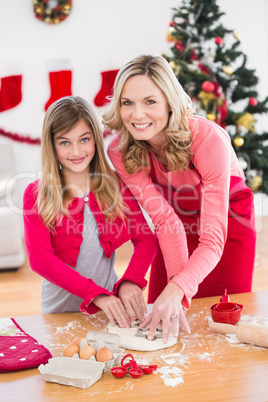 Festive mother and daughter making christmas cookies