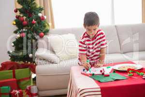 Cute boy drawing festive pictures