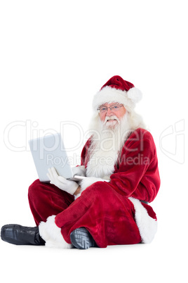 Santa sits and uses a laptop