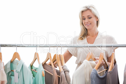 Pretty blonde looking through clothes rail