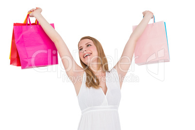 Blonde woman raising shopping bags