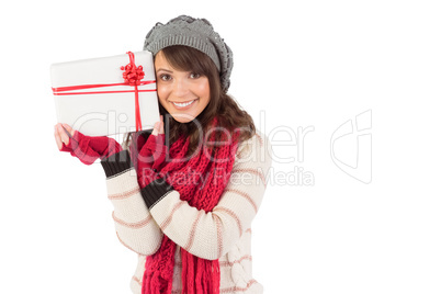 Festive brunette holding white and red gift