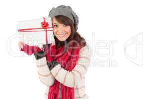 Festive brunette holding white and red gift