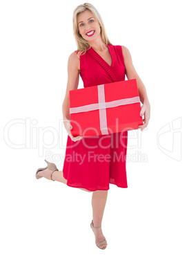 Stylish blonde in red dress holding gift