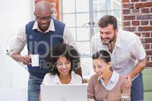 Creative business team using laptop in meeting