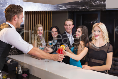 Attractive friends being served cocktails