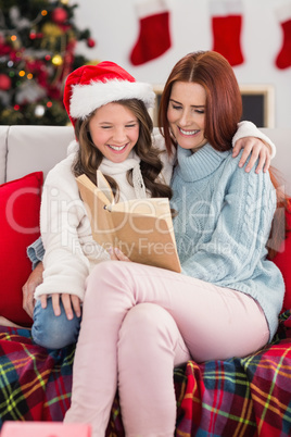 Festive mother and daughter reading on the couch