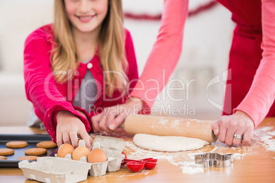 Festive mother and daughter making christmas cookies