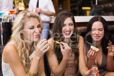 Happy friends drinking shots together