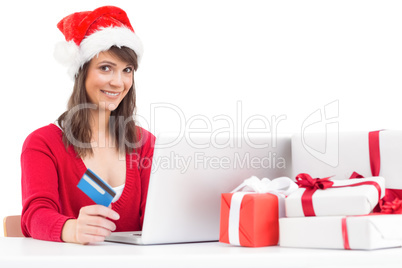 Festive brunette shopping online with laptop