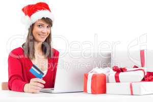 Festive brunette shopping online with laptop