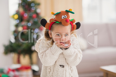 Festive little girl blowing over hands