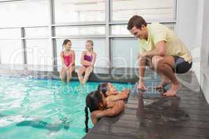 Cute swimming class listening to coach