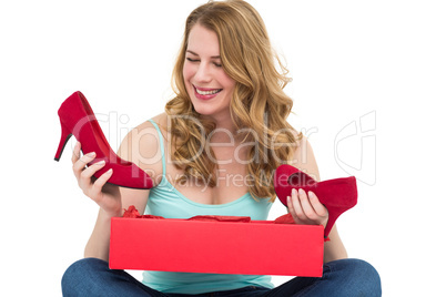 Blonde woman discovering shoes in a gift box