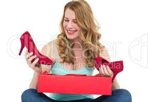 Blonde woman discovering shoes in a gift box