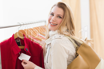 Pretty blonde smiling at price of jacket
