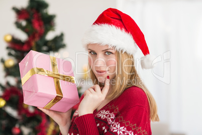 Festive woman standing holding a pink gift