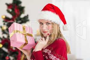 Festive woman standing holding a pink gift