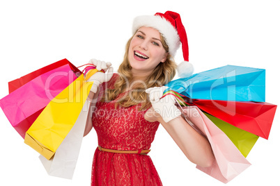 Excited blonde in santa hat holding shopping bags