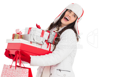 Brunette in winter clothes holding many gifts and shopping bags