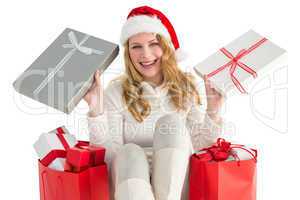 Happy woman sitting on the floor while holding gifts