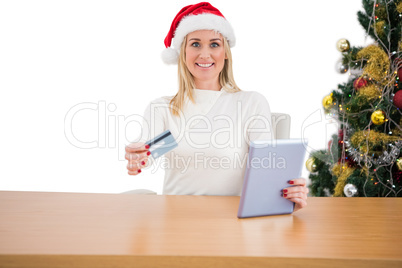 Festive blonde shopping online with tablet pc