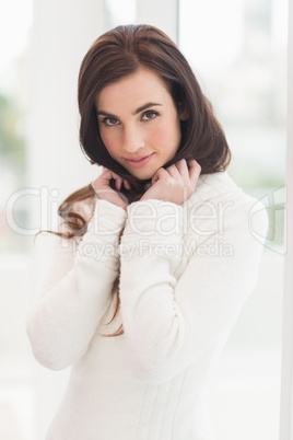 Brunette in white jumper smiling at camera