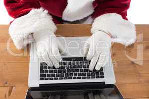 Santa is writing something on his laptop