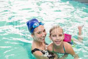 Cute little girl learning to swim with coach