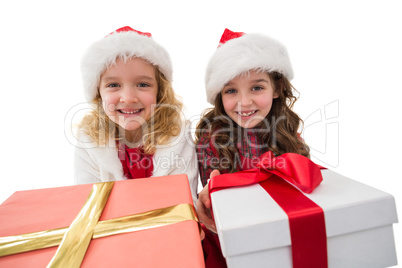 Festive little girls smiling at camera holding gifts