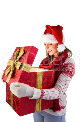 Young woman in stylish warm clothing opening a gift