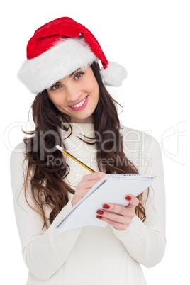 Smiling brunette writing her christmas list