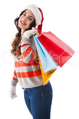 Festive brunette in winter wear holding shopping bags