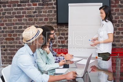Casual businesswoman giving presentation to colleagues