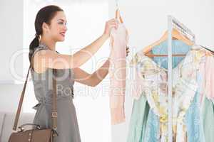 Happy shopping brunette looking at shirt