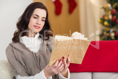 Relaxed brunette reading on the couch at christmas