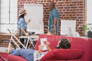 Relaxed casual man lying and writing note on couch