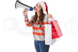 Festive brunette holding gift bags and megaphone