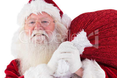 Santa carries his red bag and smiles