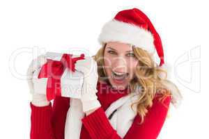 Pretty santa girl smiling at camera holding gift