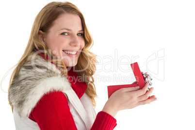 Surprised woman opening gift while looking at camera