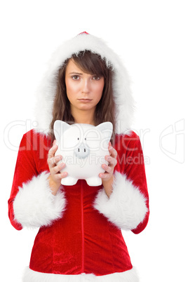 Sad festive woman holding a piggy bank in her hands