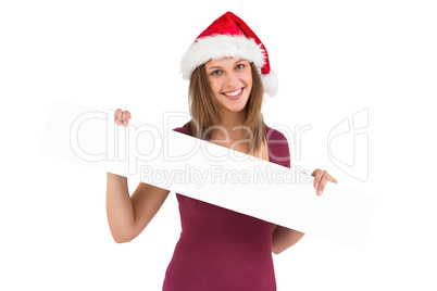 Festive brunette in santa hat showing a blank banner