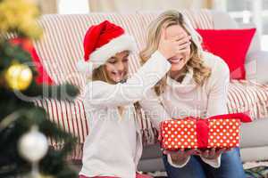 Festive mother and daughter with gift