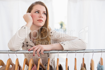 Pretty blonde thinking through clothes rail