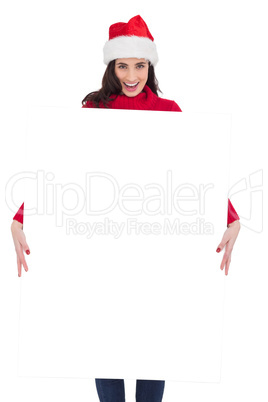 Happy brunette in santa hat showing white poster