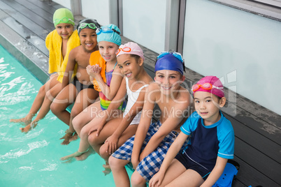 Cute swimming class smiling poolside