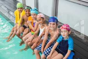 Cute swimming class smiling poolside