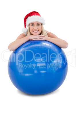 Festive fit blonde leaning on exercise ball
