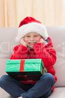 Festive little boy smiling at camera with gift